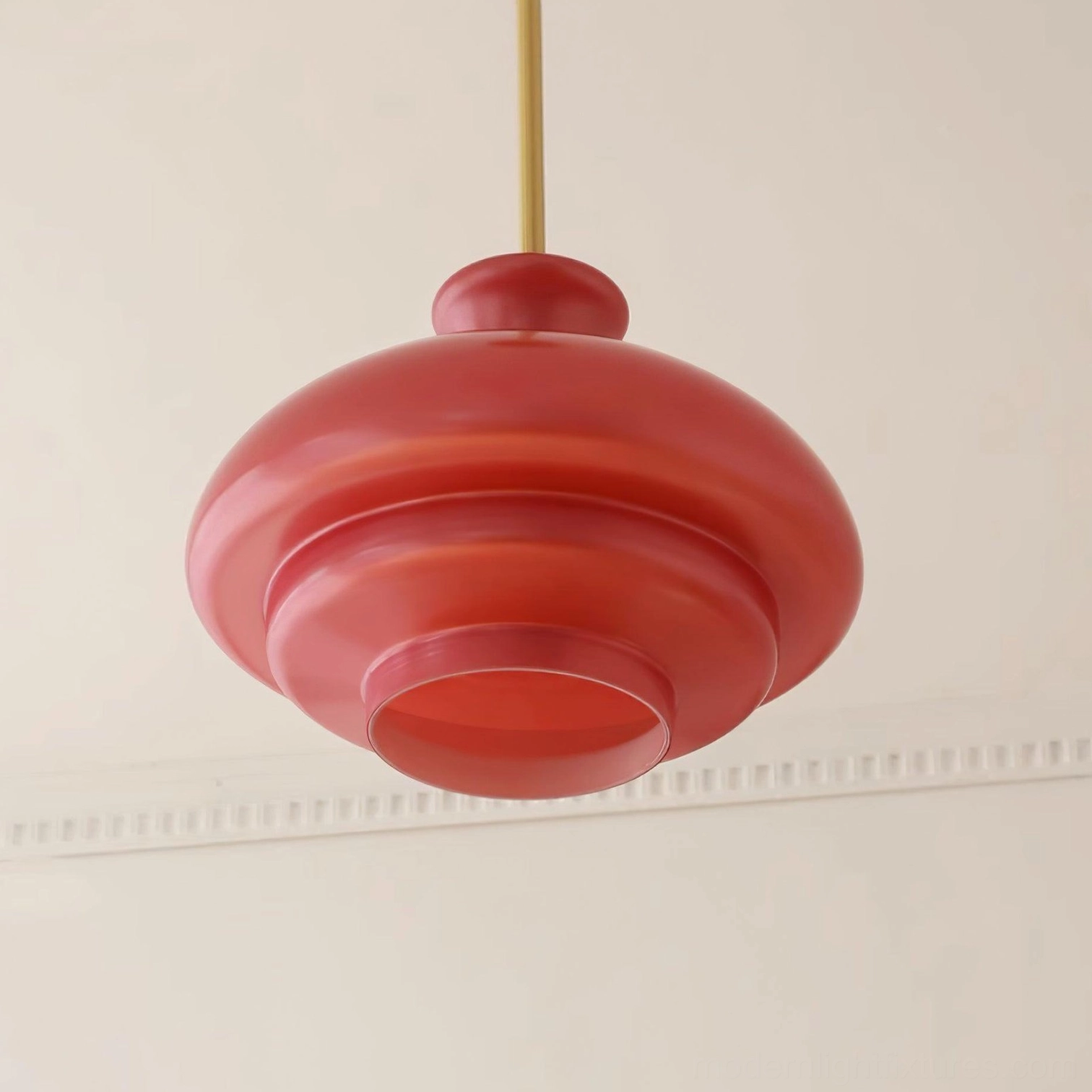 Paolina tiered glass pendant light hanging in minimalist interior space, clean modern aesthetic with brass rod