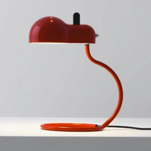 Paolo modern metal table lamp front three-quarter view with orange-red enamel finish and curved metal stem on studio display shelf