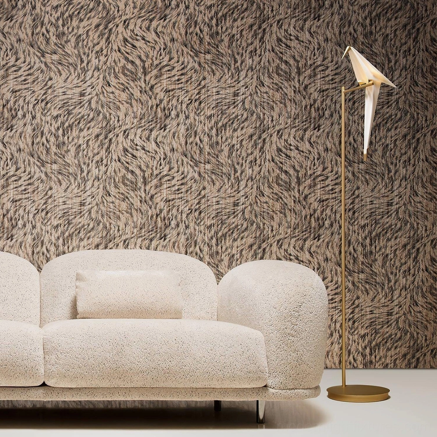 Paper crane floor lamp next to boucle beige sofa with textured wallpaper, side profile view