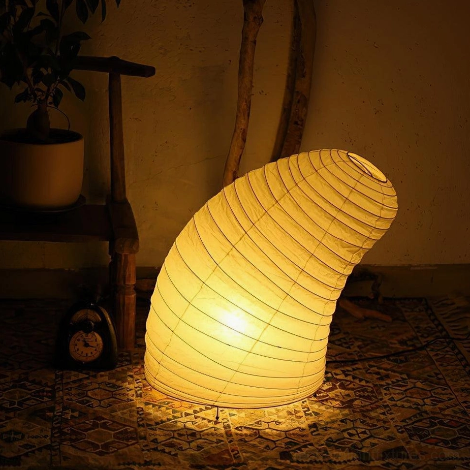 Contemporary paper table lamp with warm ambient glow in vintage living room setting, low side angle view