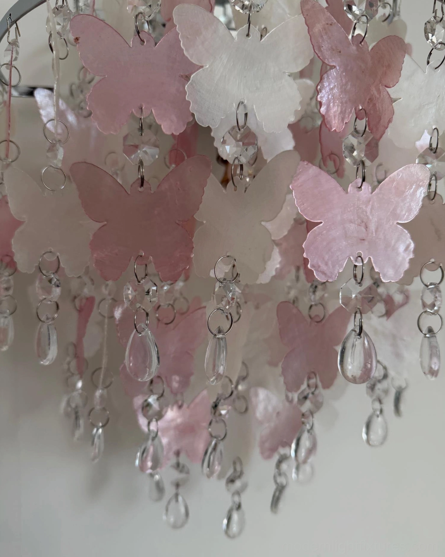 Papillia tiered butterfly crystal wall sconce illuminated displaying soft romantic glow through layered butterflies and crystals