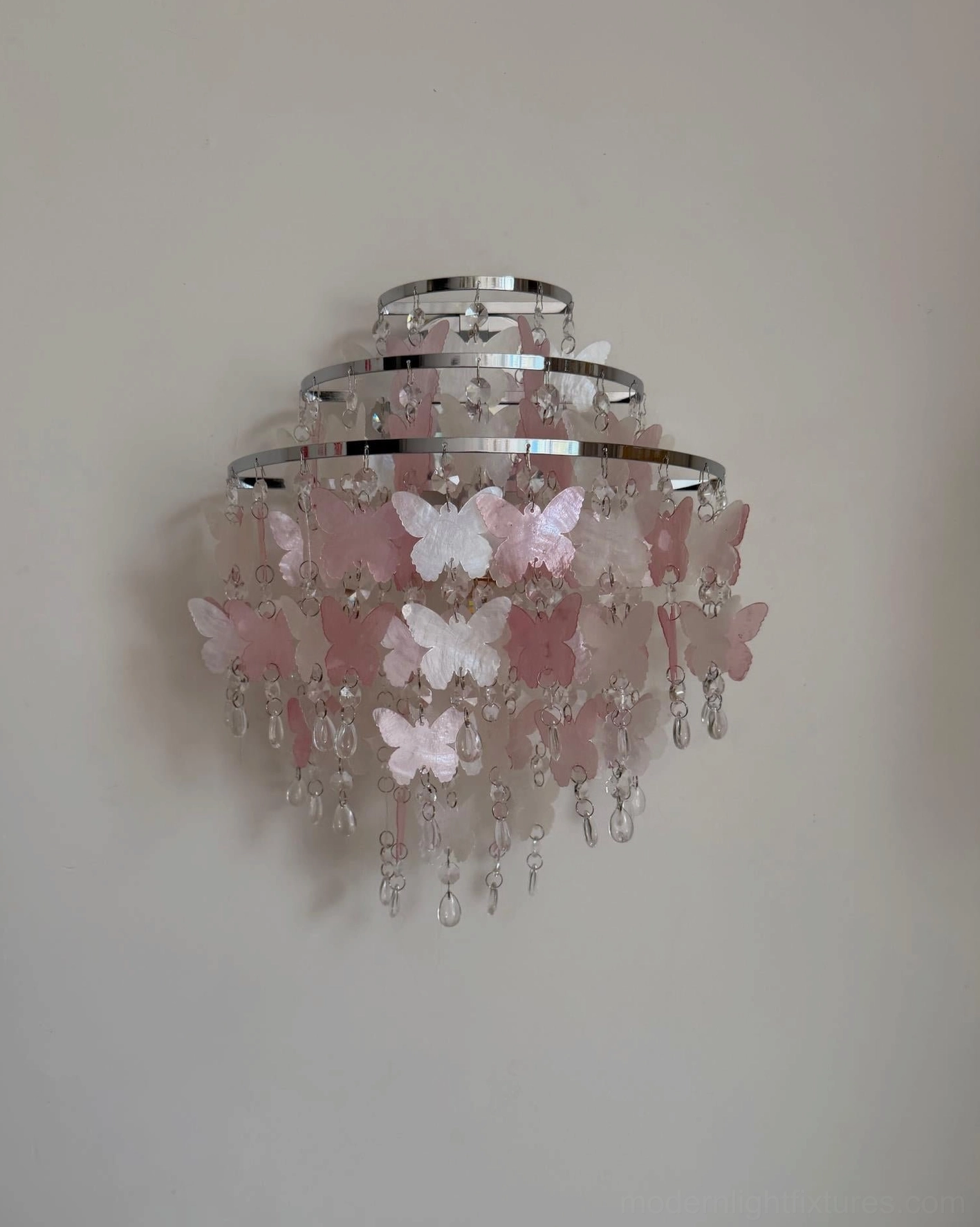 Papillia tiered pink butterfly crystal wall sconce close-up showing three-tier chrome frame with crystal and butterfly details