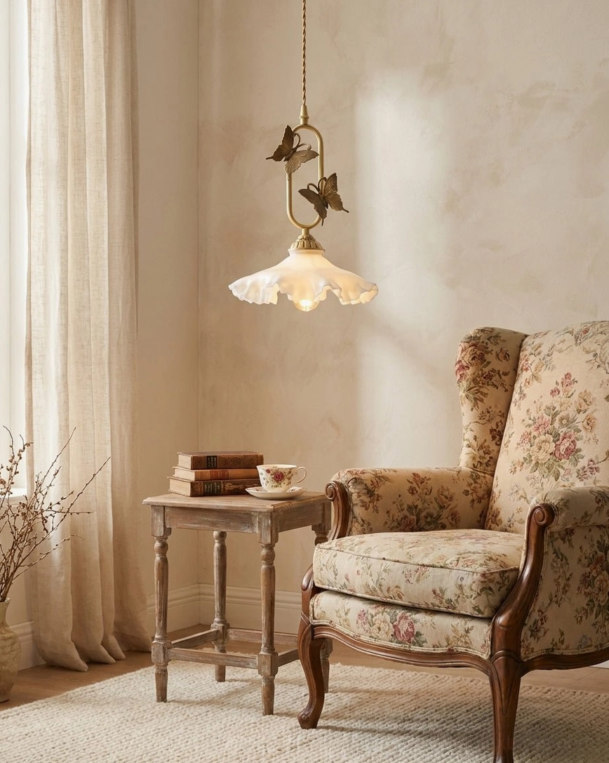 Papilora butterfly pendant light close-up showing cast brass butterfly wing detail and curved brass arm construction