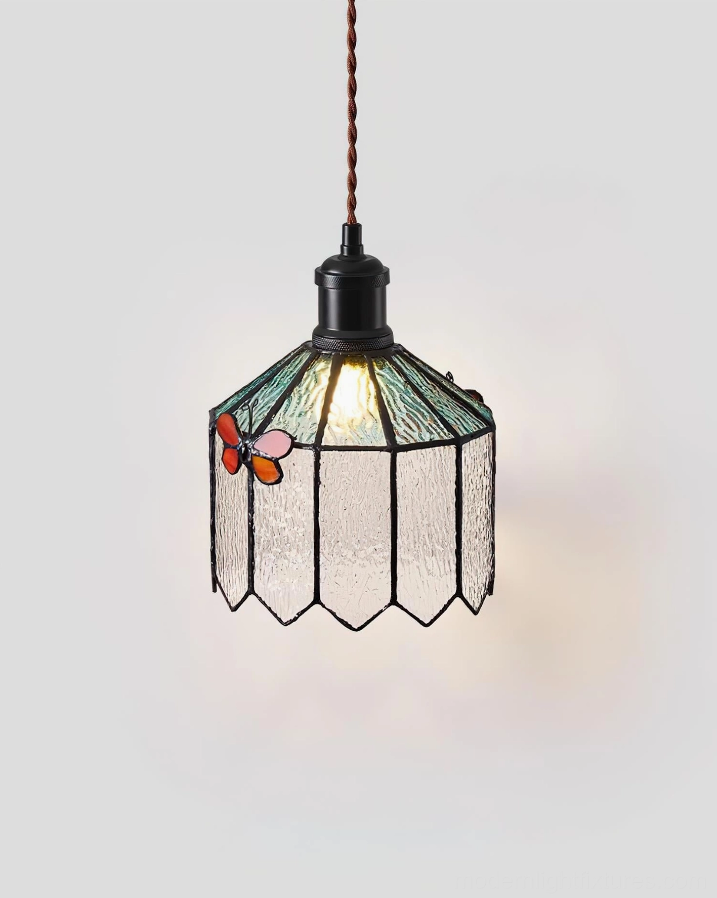 Papilune pendant light front view lit showing twisted hanging cord and soft green stained glass aesthetic