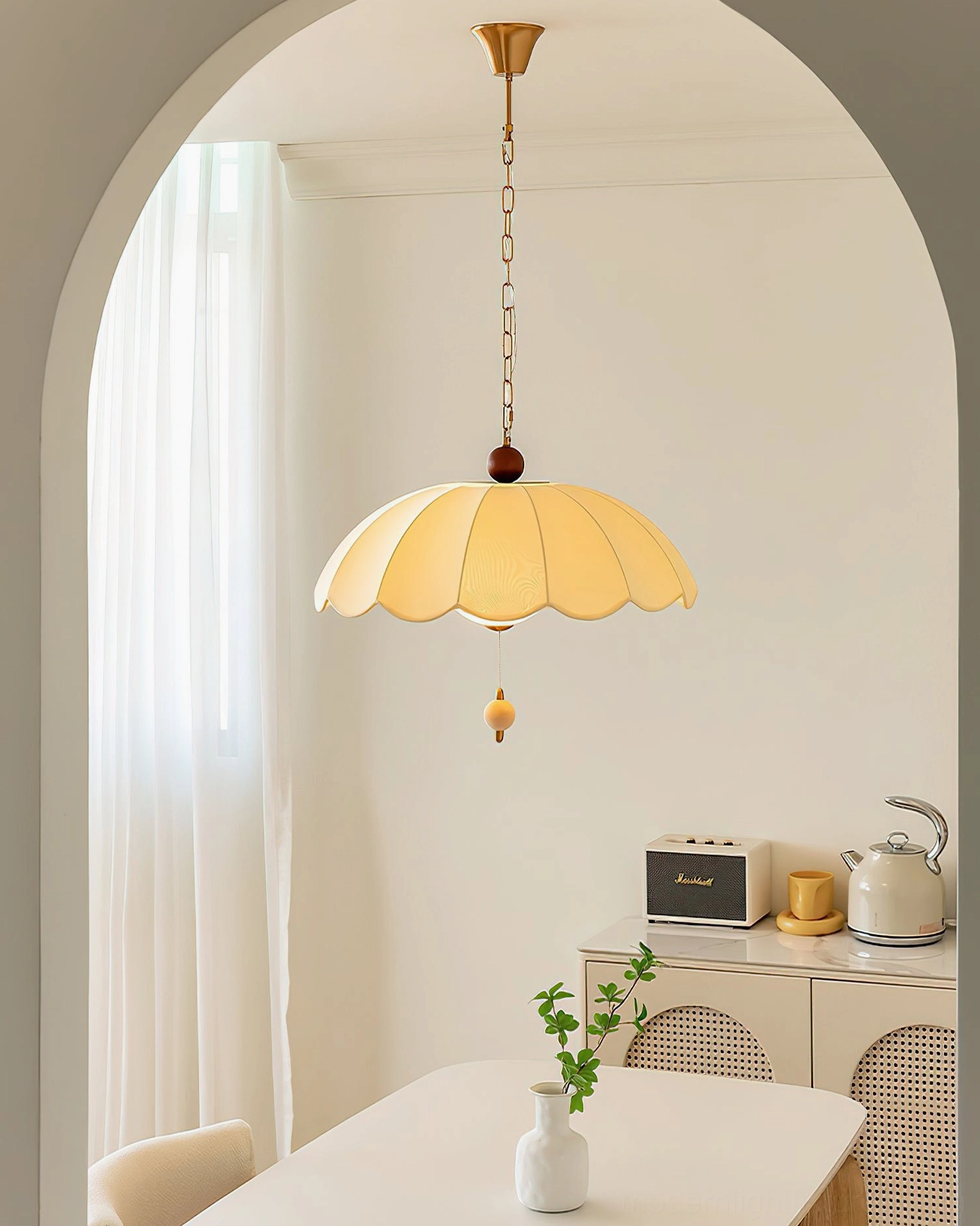 Paralune scalloped pendant lamp in warm yellow, installed in French-style dining room with arched doorway