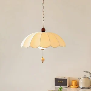 Paralune pendant light in warm tan with brass chain and bead accent, displayed in minimalist interior setting