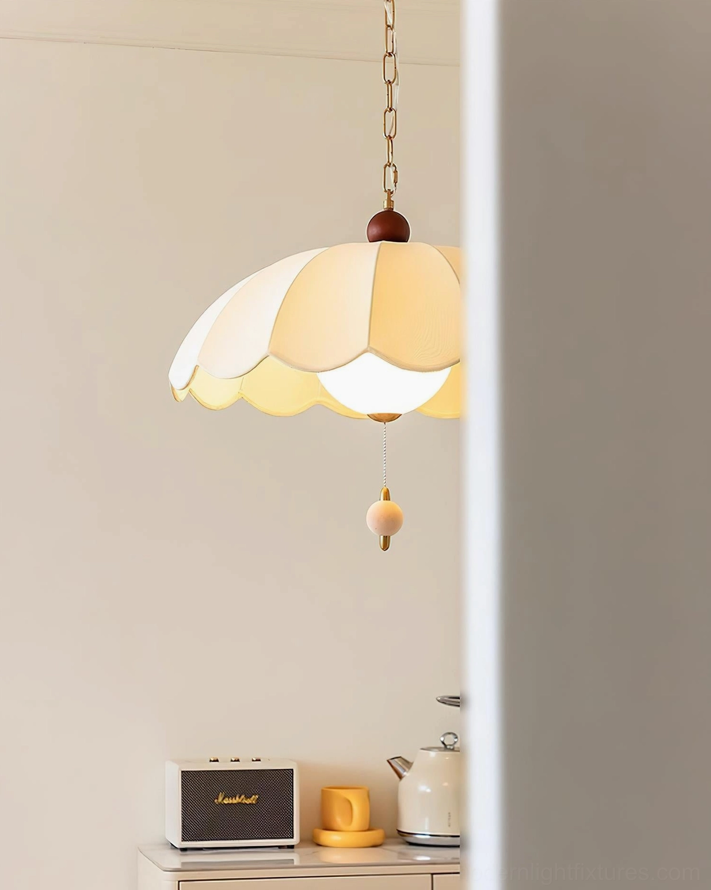 Paralune pendant light with illuminated warm yellow fabric shade and compact bead accent, minimalist backdrop