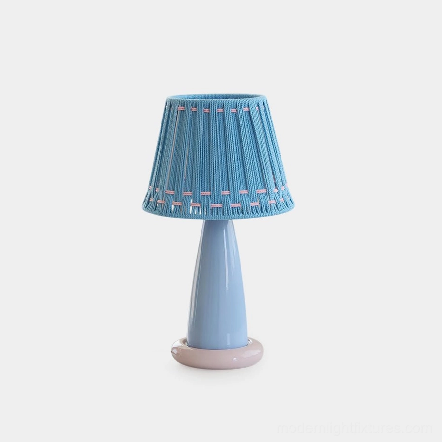 Pastel ceramic table lamp with blue woven shade and light blue ceramic base featuring pink accent ring, minimalist modern design on white backdrop