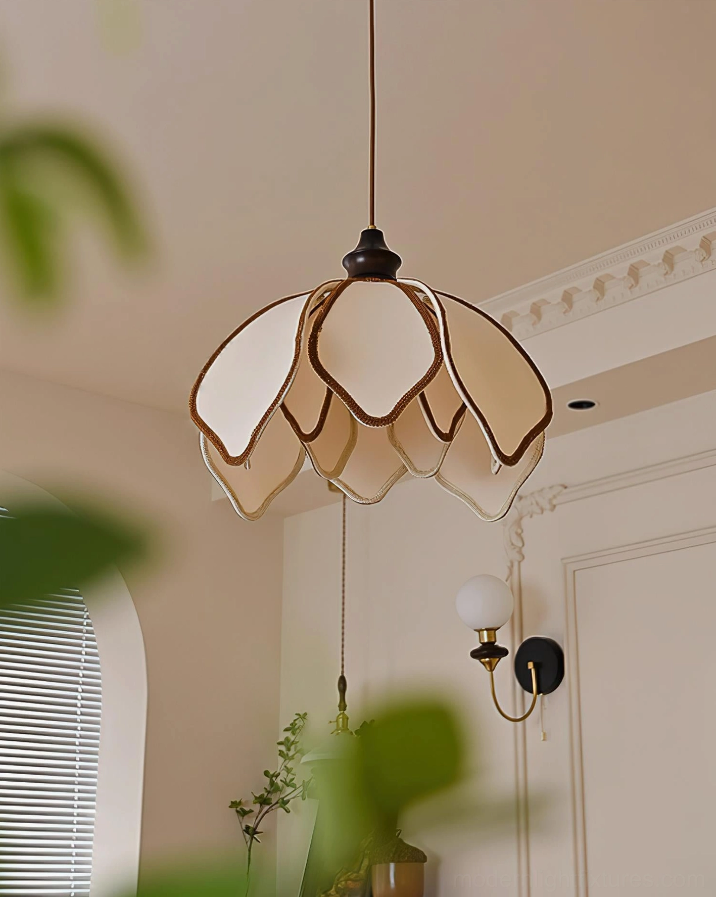 Pauline petal pendant light low front angle with soft blurred foliage foreground, green plants, warm glowing illumination
