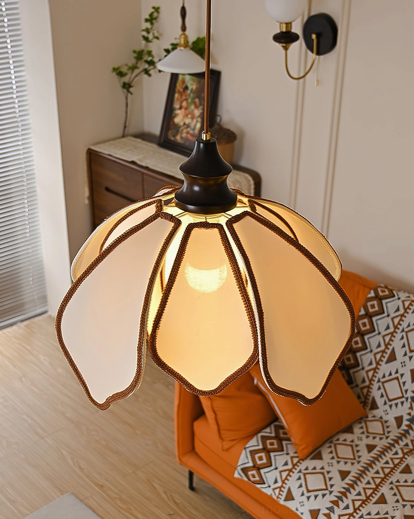 Pauline petal pendant light installed in retro living room with orange sofa, cottage vintage aesthetic, warm lighting