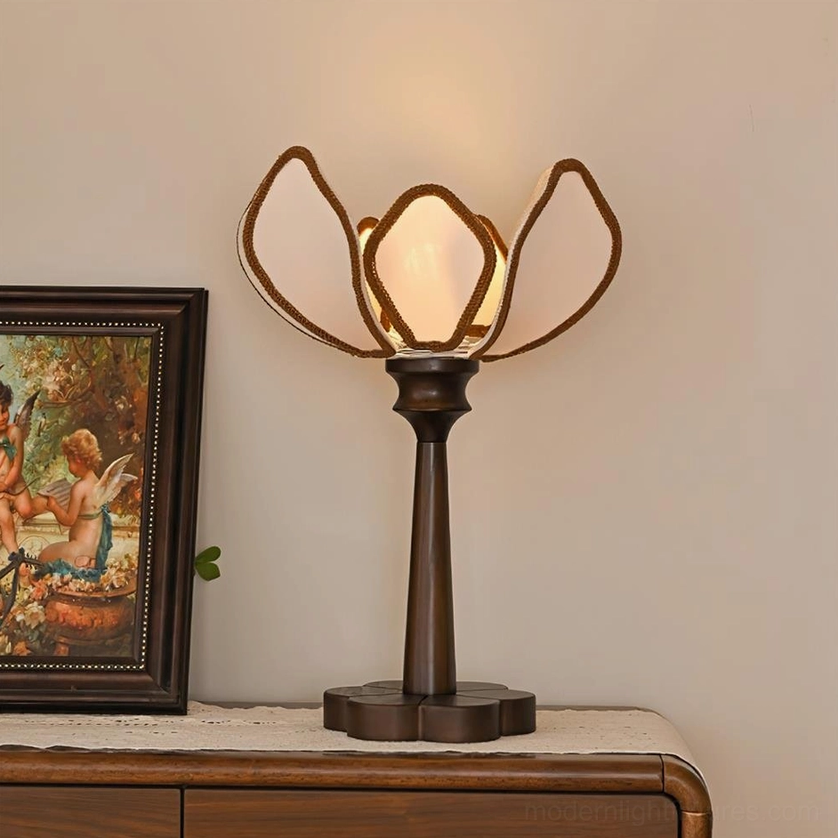 Pauline floral table lamp front lit view on wooden table with vintage framed artwork and wall backdrop