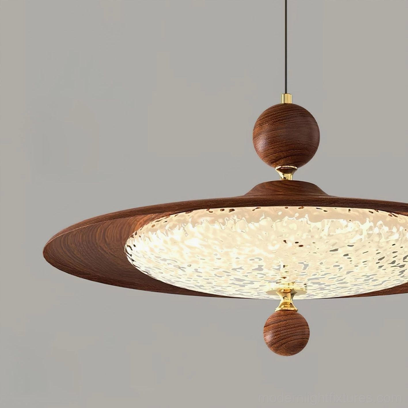 Close-up detail of Pavilion swing arm pendant lamp shade, textured acrylic with carved wooden decorative balls, hammered light-diffusing surface