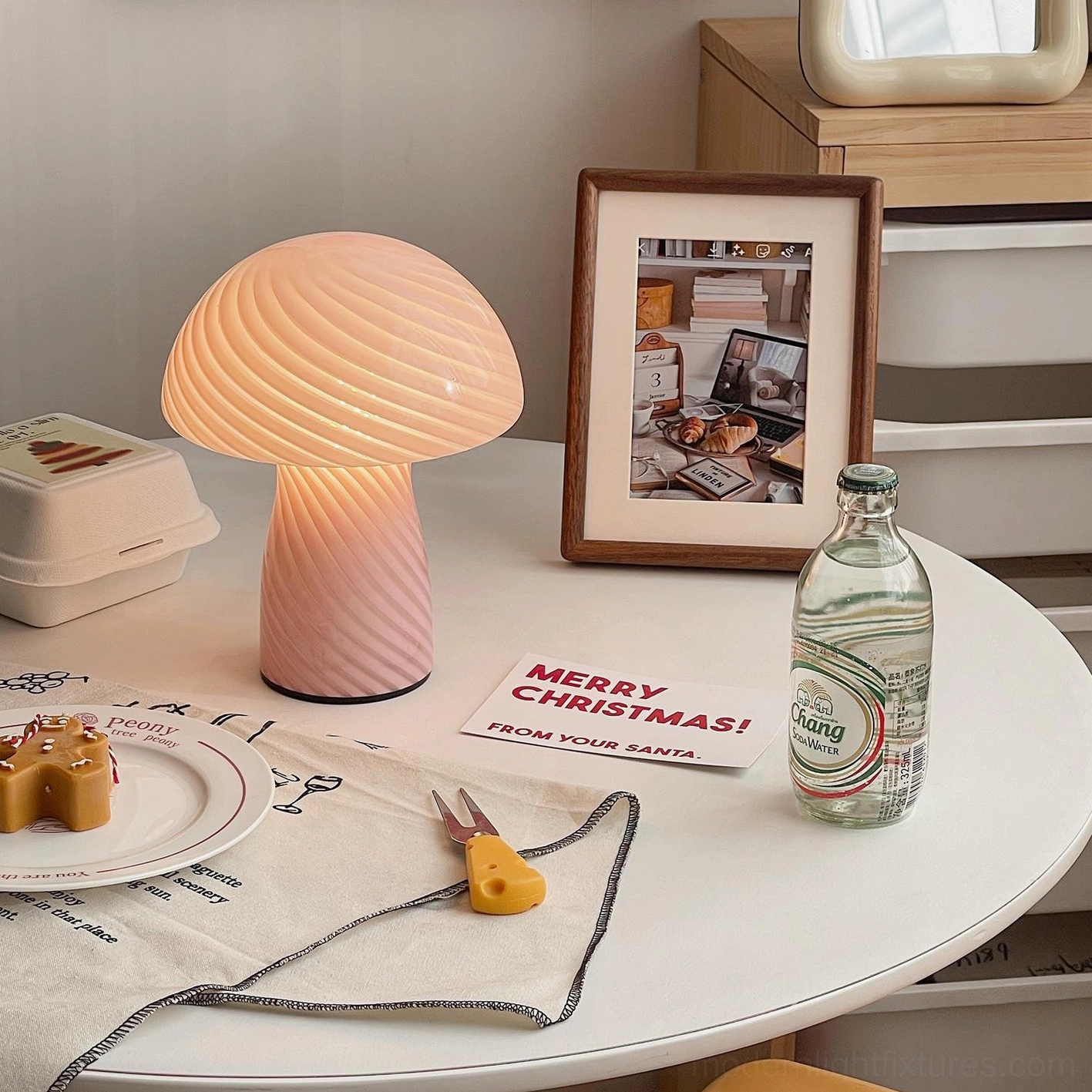 Peach warm-toned mushroom glass table lamp side view on white desktop workspace