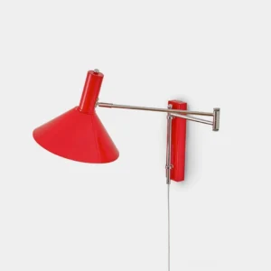 Peak red swing arm wall sconce lamp with conical metal shade on white background studio photography