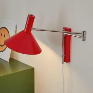 Peak red plug-in wall sconce with extendable chrome arm positioned three-quarter view in modern home corner
