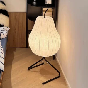 Modern pear floor lamp glowing in bedroom corner with wooden flooring and Nordic minimalist style