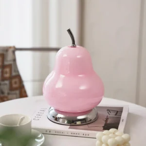 Pear shaped table lamp displayed on tabletop with coffee cup and magazine, three-quarter rear view