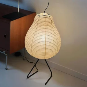 Modern rice paper floor lamp with warm beige ribbed shade and black metal tripod stand in contemporary home interior