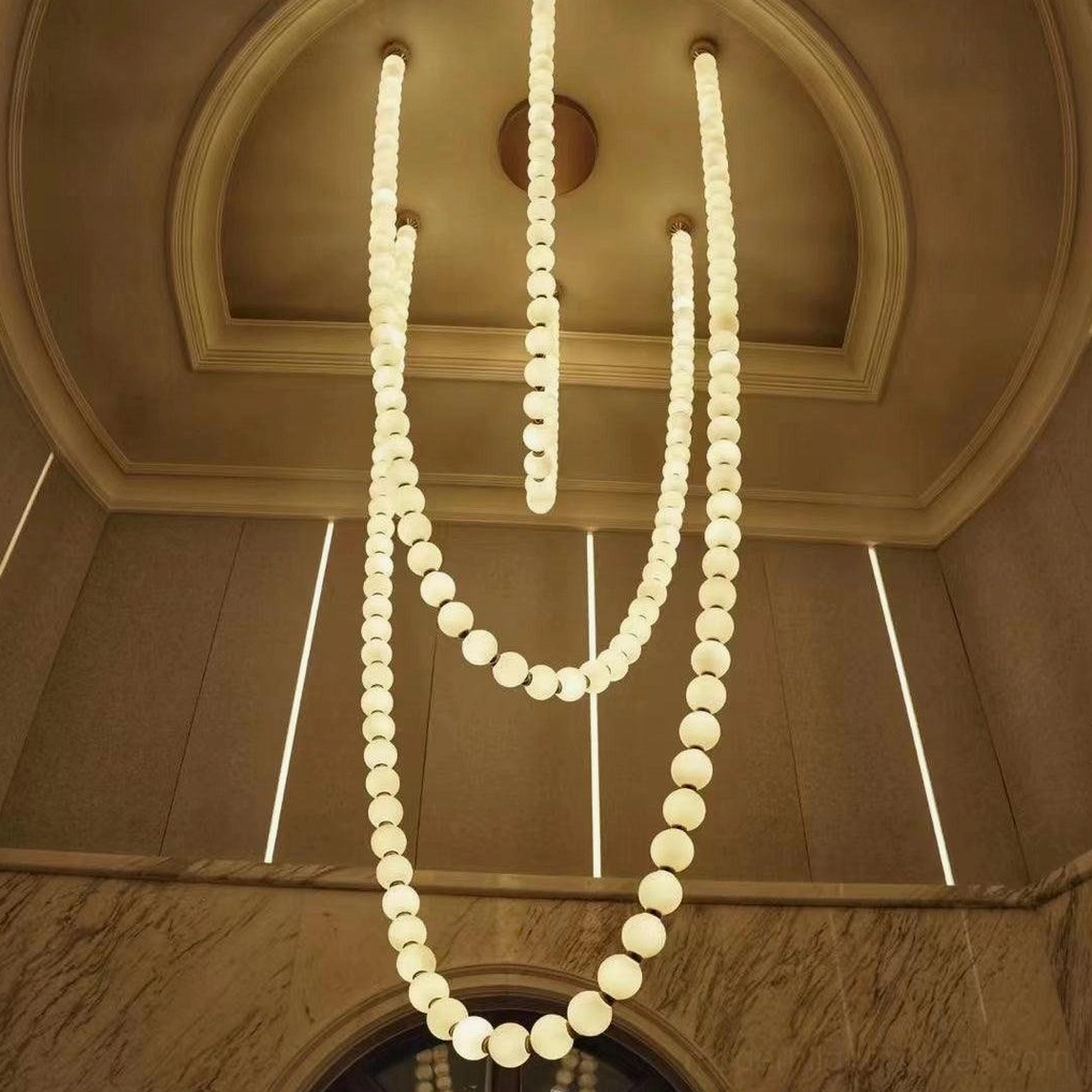 Contemporary pearl chandelier detail showing brass joints connecting frosted acrylic sphere elements