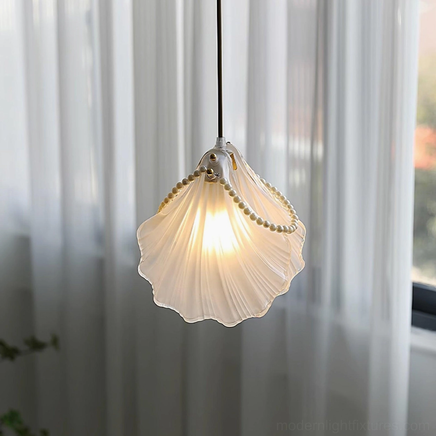 Illuminated pearl shell pendant lamp with scalloped glass and warm internal glow detail