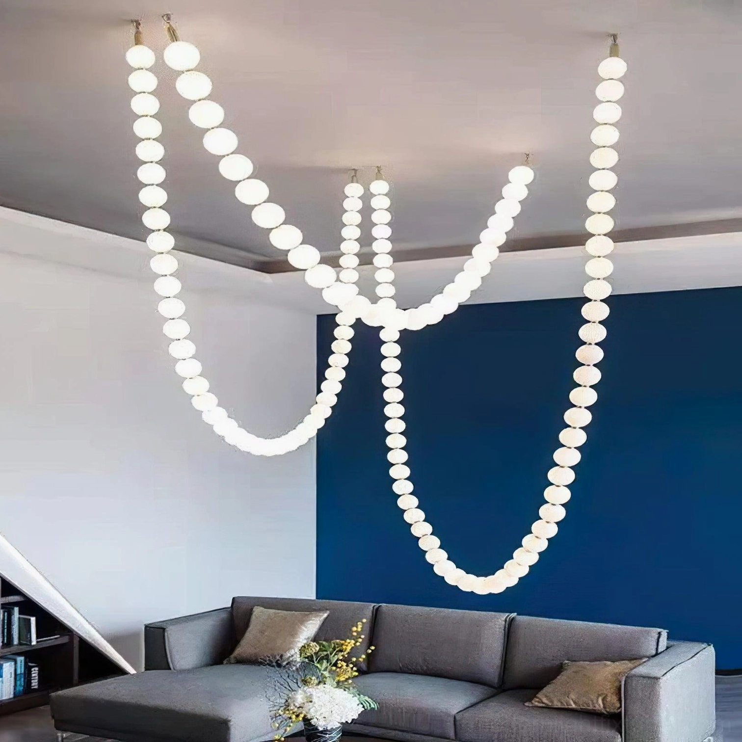 Contemporary pearl necklace chandelier installed in modern living room overhead view with illuminated frosted globes