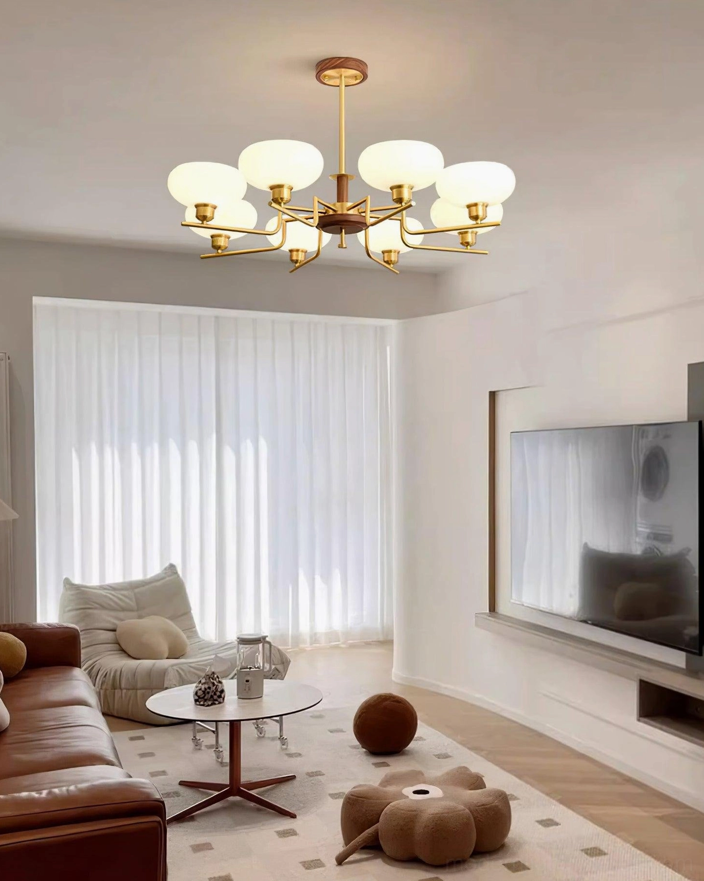 Modern pendant chandelier installation overhead view showing brass hanging hardware and frosted glass shade diffusion