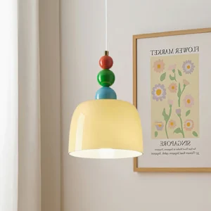 Cream glass shade pendant light with colorful beaded finial in residential bedroom corner setting
