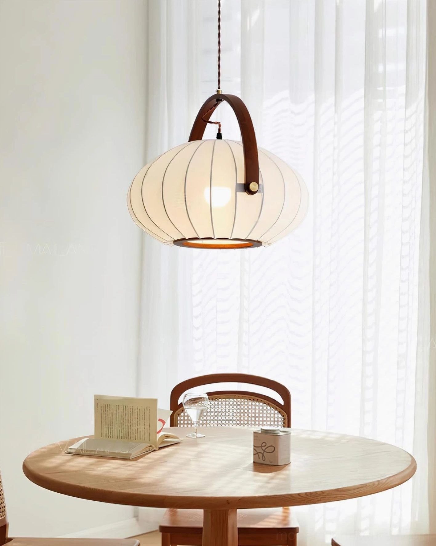 Antonio pendant light suspended above round wooden dining table in contemporary modern dining room