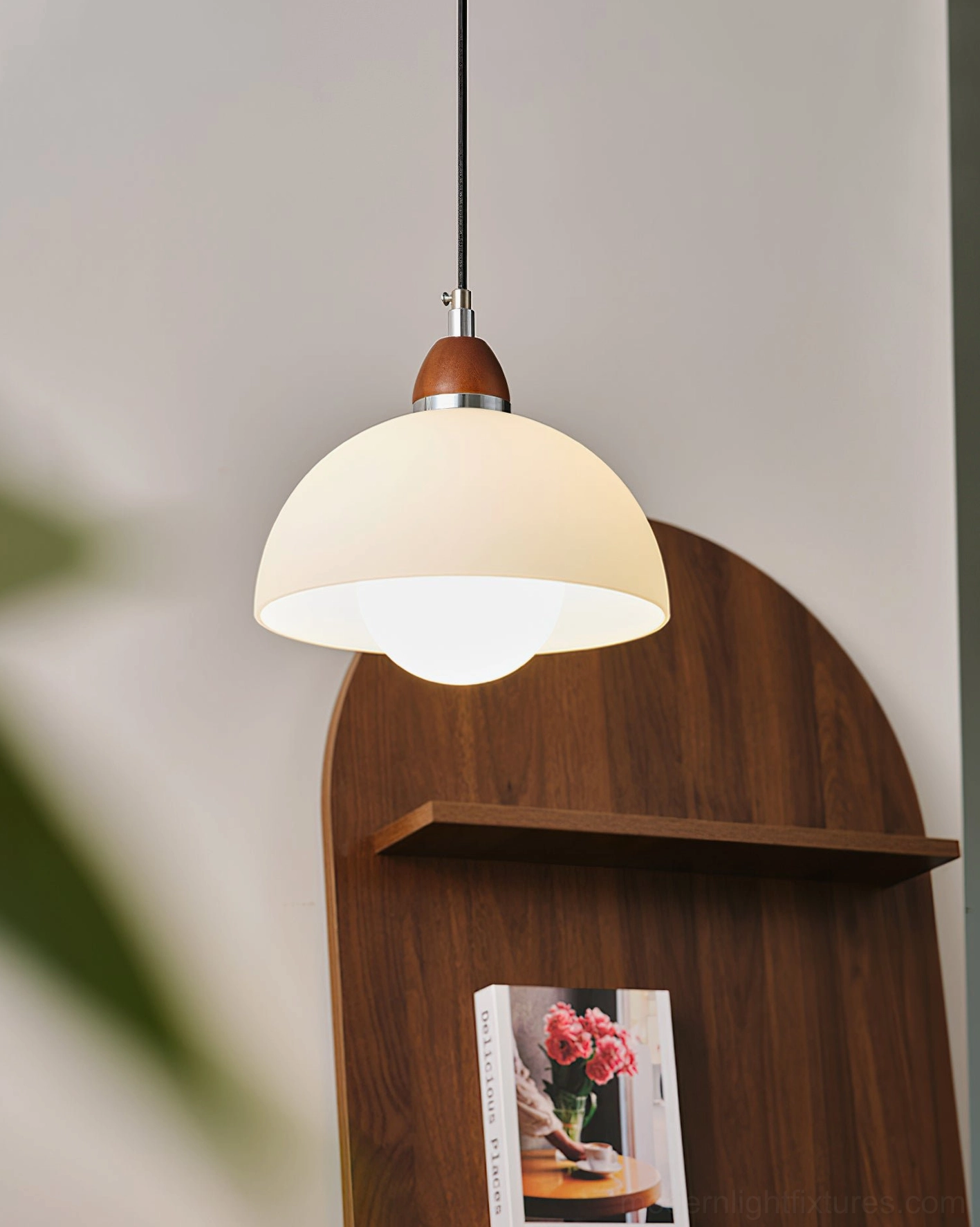 Single domed pendant lamp side view, cream-colored matte shade with warm illuminated bulb, minimalist home décor