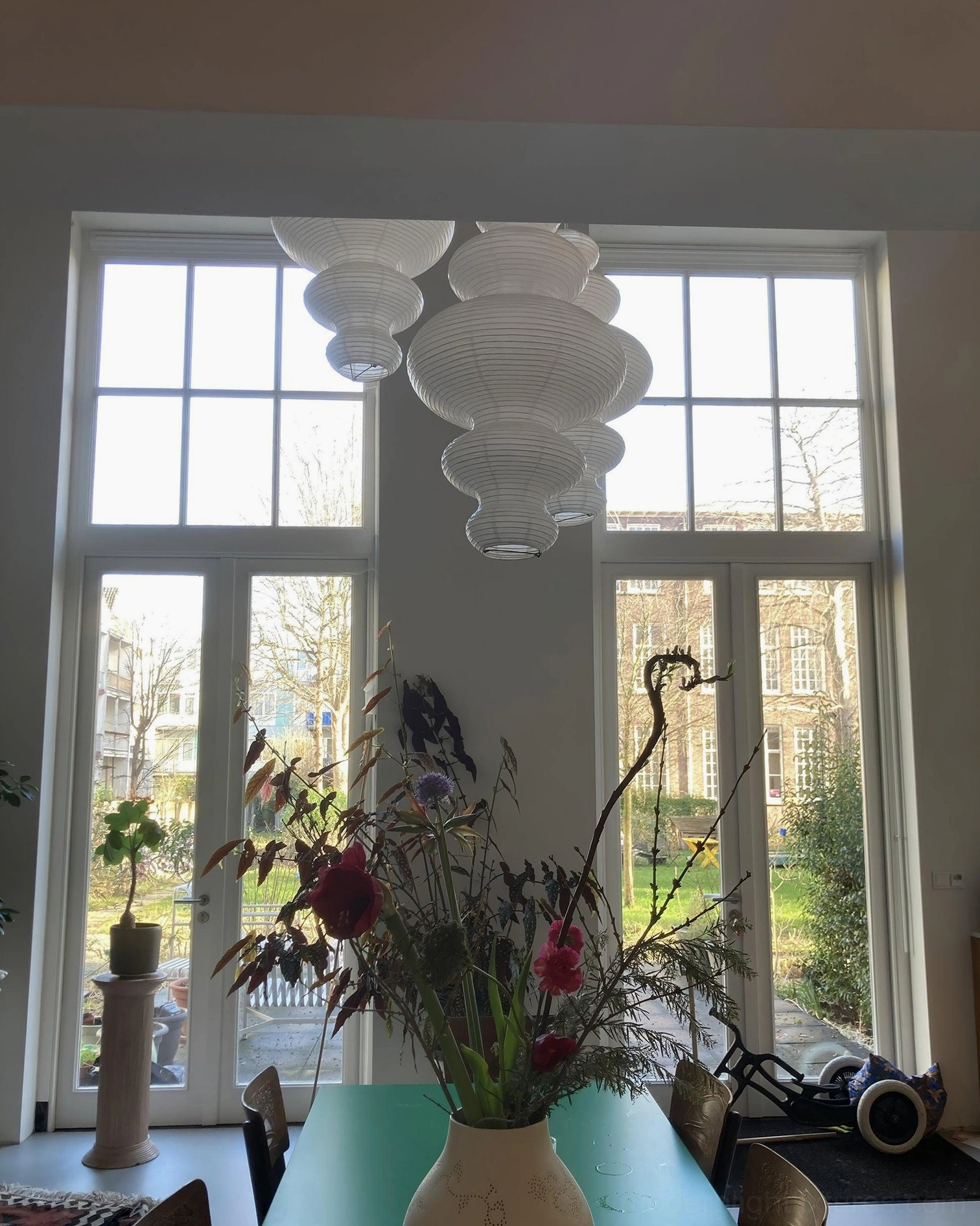 Sculptural rice paper pendant lamp in bedroom setting above bedside creating restful warm glow