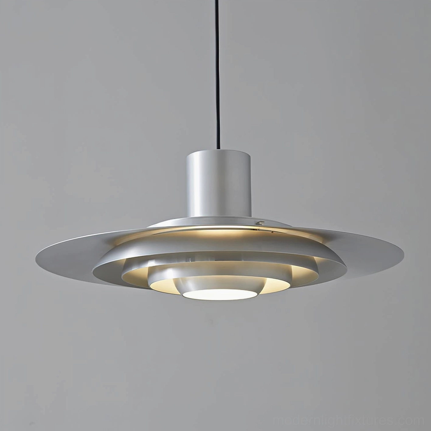 Close-up front view of layered aluminum disc shade pendant light with warm illumination, sleek metal construction detail