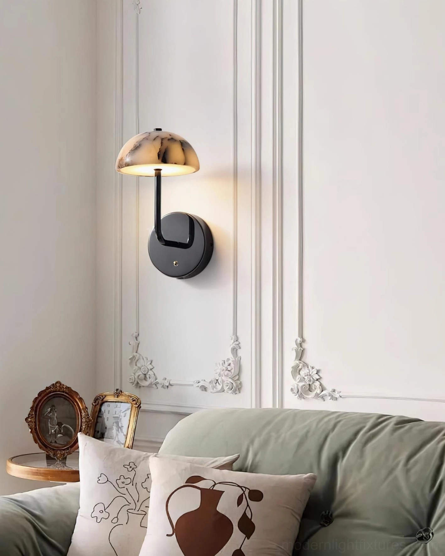 Penta marble wall sconce side view in contemporary living room with green sofa and molded wall accent