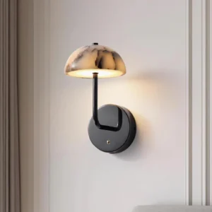 Penta modern wall lamp three-quarter angle showing black curved metal arm and marble dome on decorative molded wall