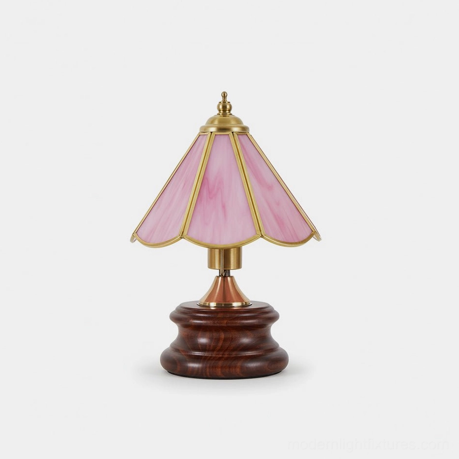 Peony pink stained glass table lamp with scalloped glass shade and brass trim on dark wood base, front studio view