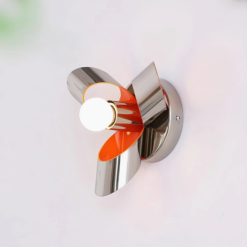 Petala chrome orange wall sconce with exposed white bulb and silver metal frame with orange petal accents on white studio background