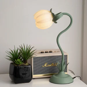 Petala modern sculptural table lamp illuminated on home desk with vintage speaker and potted plants