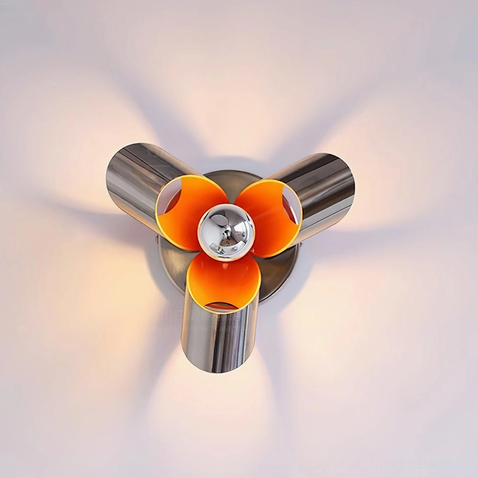 Illuminated Petala wall sconce with exposed bulb casting radial warm shadows and polished silver metal finish, direct front view