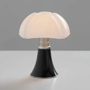 Petalica adjustable table lamp three-quarter view showing flared black base with silver trim and white acrylic petal shade on gray tabletop
