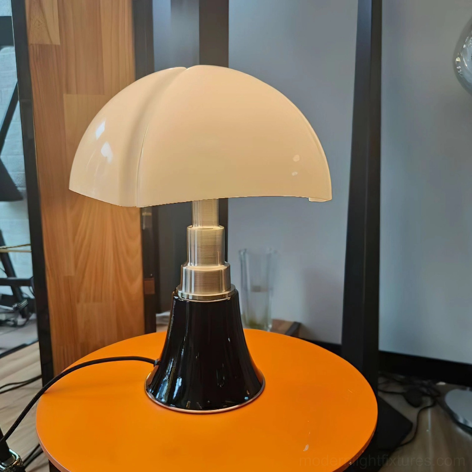 Petalica petal lamp on orange round side table in modern lounge with wood panel wall and beige shade detail
