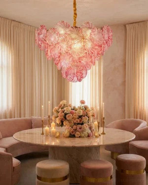 Pink swirl glass disc chandelier hanging in luxury dining room interior with warm neutral decor and brass hardware