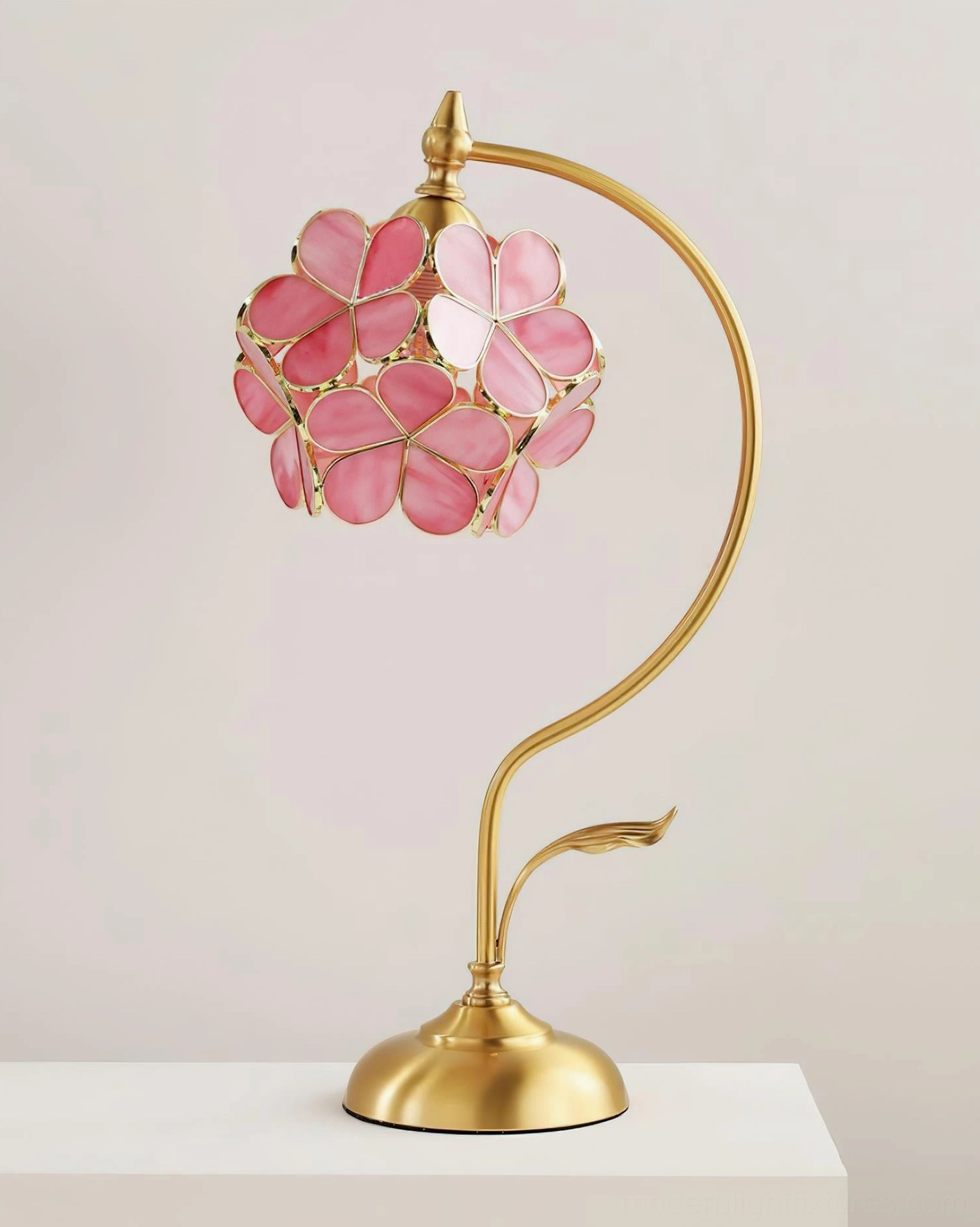 Pink Petalora stained glass petal table lamp on display shelf showcasing elegant brass and glass construction