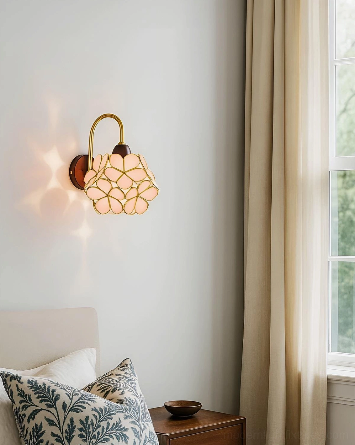Petalora wall sconce in bedroom setting with warm ambient light, cream finish on nightstand wall