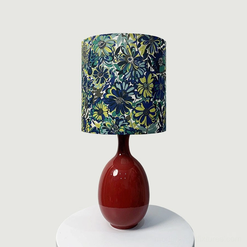 Petalyn ceramic table lamp with blue and green floral fabric drum shade and glossy oxblood red base, front view