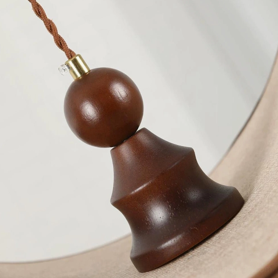Petavin pendant light hardware detail close-up showing walnut wood bead finial and brass-tone twisted cord junction