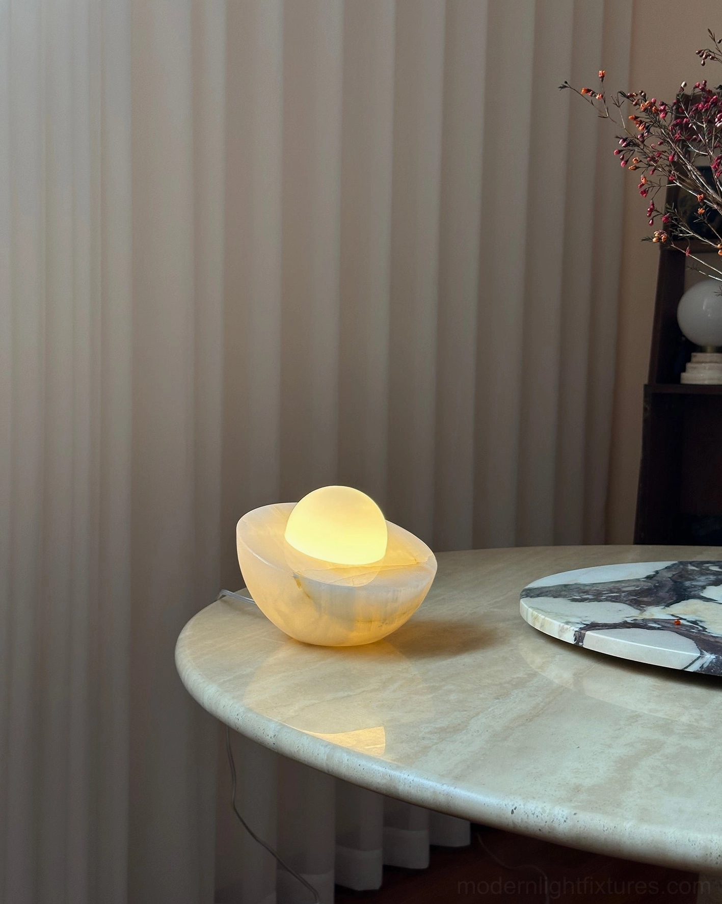 Lit Piccola onyx table lamp warm glow ambient lighting home dining table setting with marble veining detail