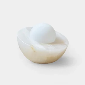 Piccola natural onyx table lamp with frosted glass diffuser, top view on white background showcasing creamy marble texture and veining