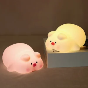 Two pig silicone night lights comparison - one unlit pink and one lit warm white, showing illumination difference