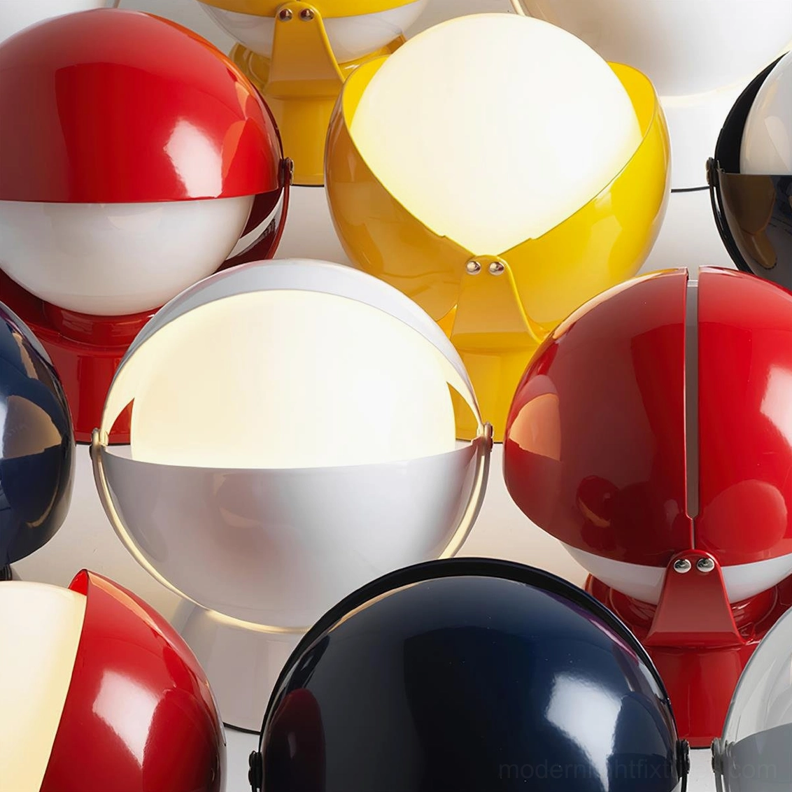 Overhead close-up of multiple Pileino table lamps with glowing warm interior light and mixed colored shades