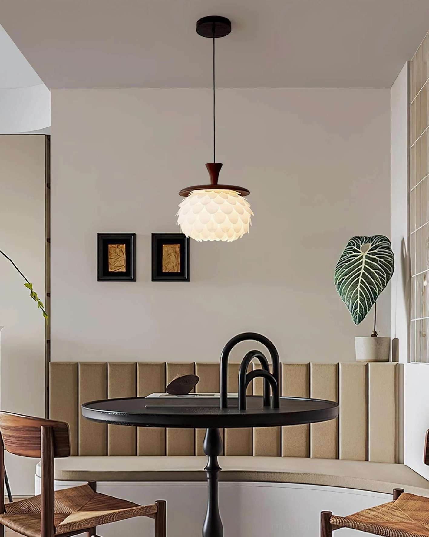 Pinecone petal pendant light at eye-level in cafe-style dining nook with tufted beige wall and minimalist dark table decor