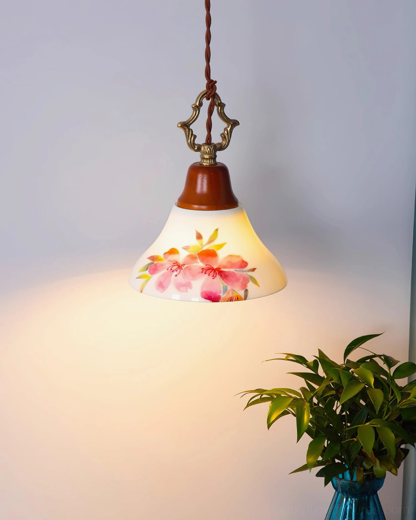 Illuminated pink azalea pendant light casting warm ambient glow in corner interior with potted plant